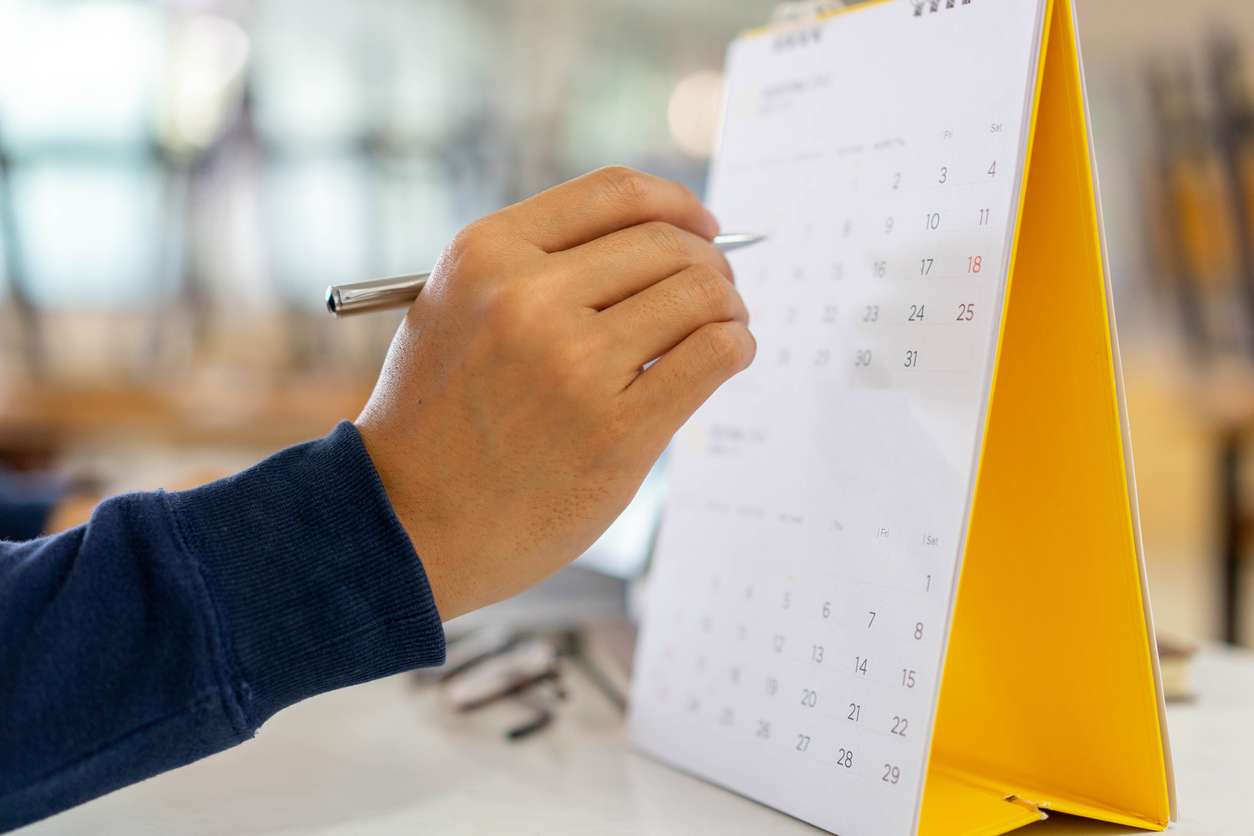 Businessman counting the days on a calendar - a concept of managing employee leaves.