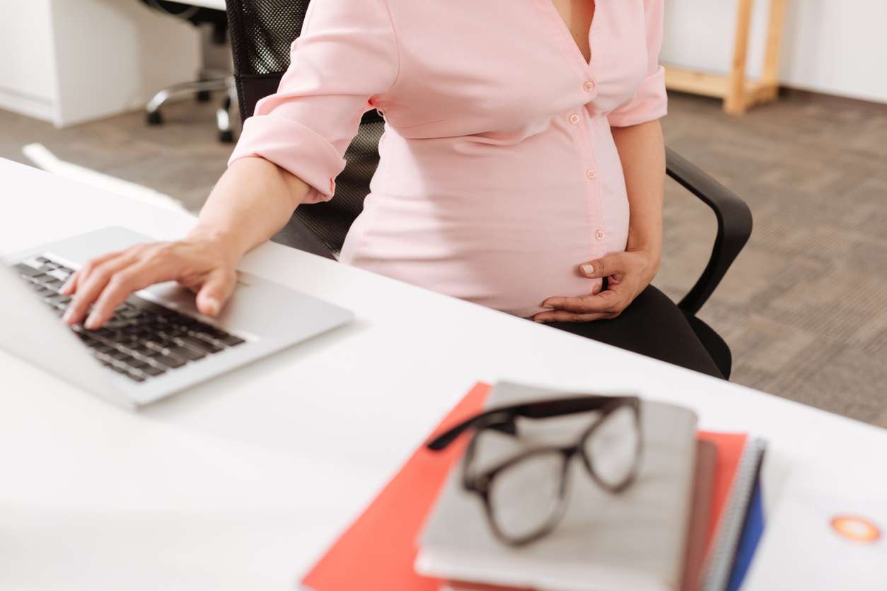 Pregnant employee working in an office.
