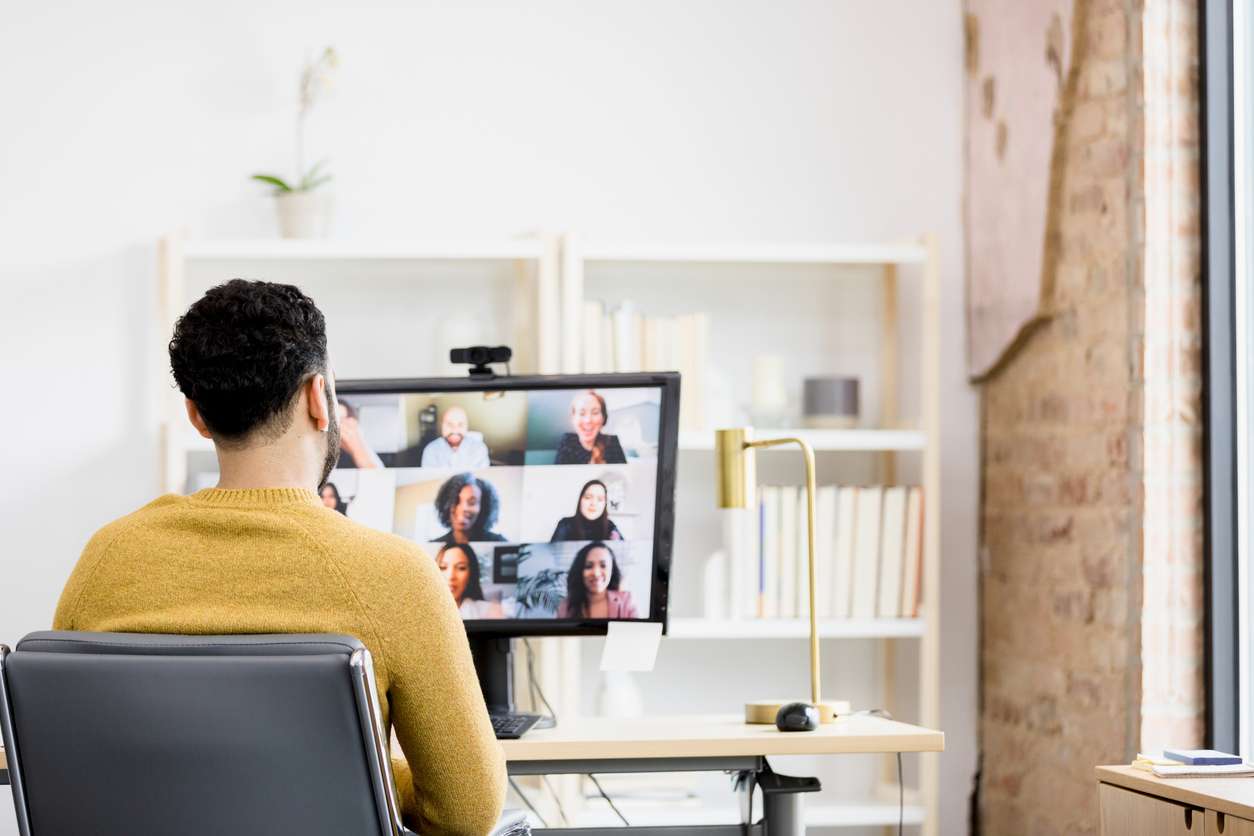 Managing remote staffing - A male employee having a virtual meeting with his colleagues.