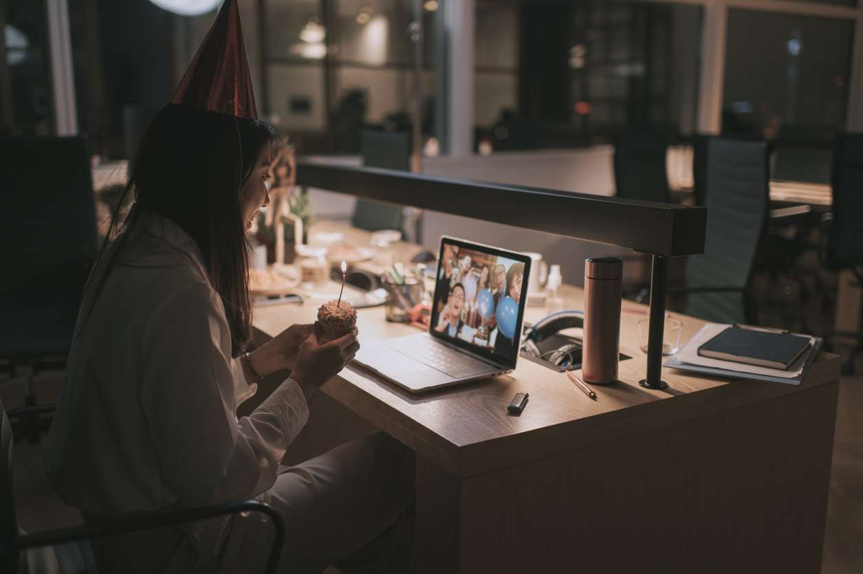 A female remote employee celebrating her birthday with her colleagues through a video call.