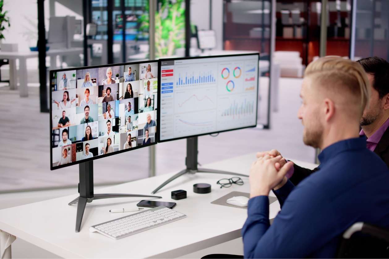 Hiring internal remote teams - A businessman using his computer while having a virtual meeting with his employees.