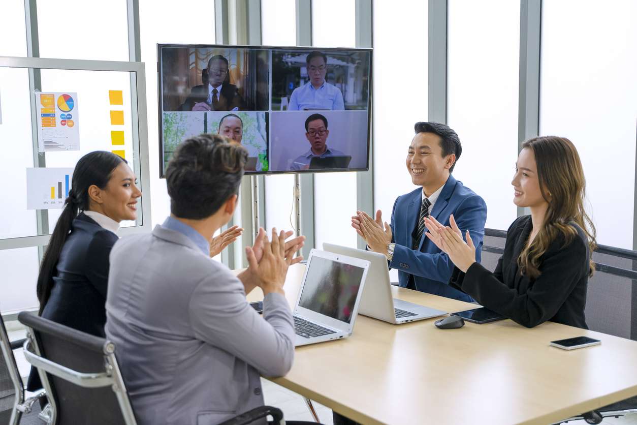 Employees, prioritizing employee engagement, clapping their hands while in a virtual meeting.