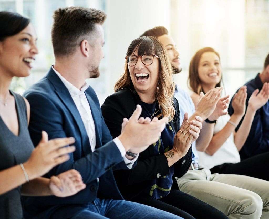 Group of employees applauding during a meeting.