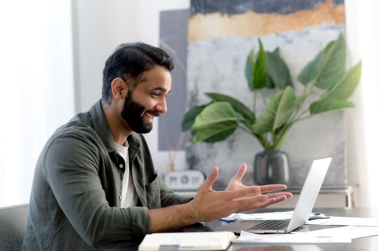 Improving team building for remote workers - A male employee on a video conference call with his colleague.