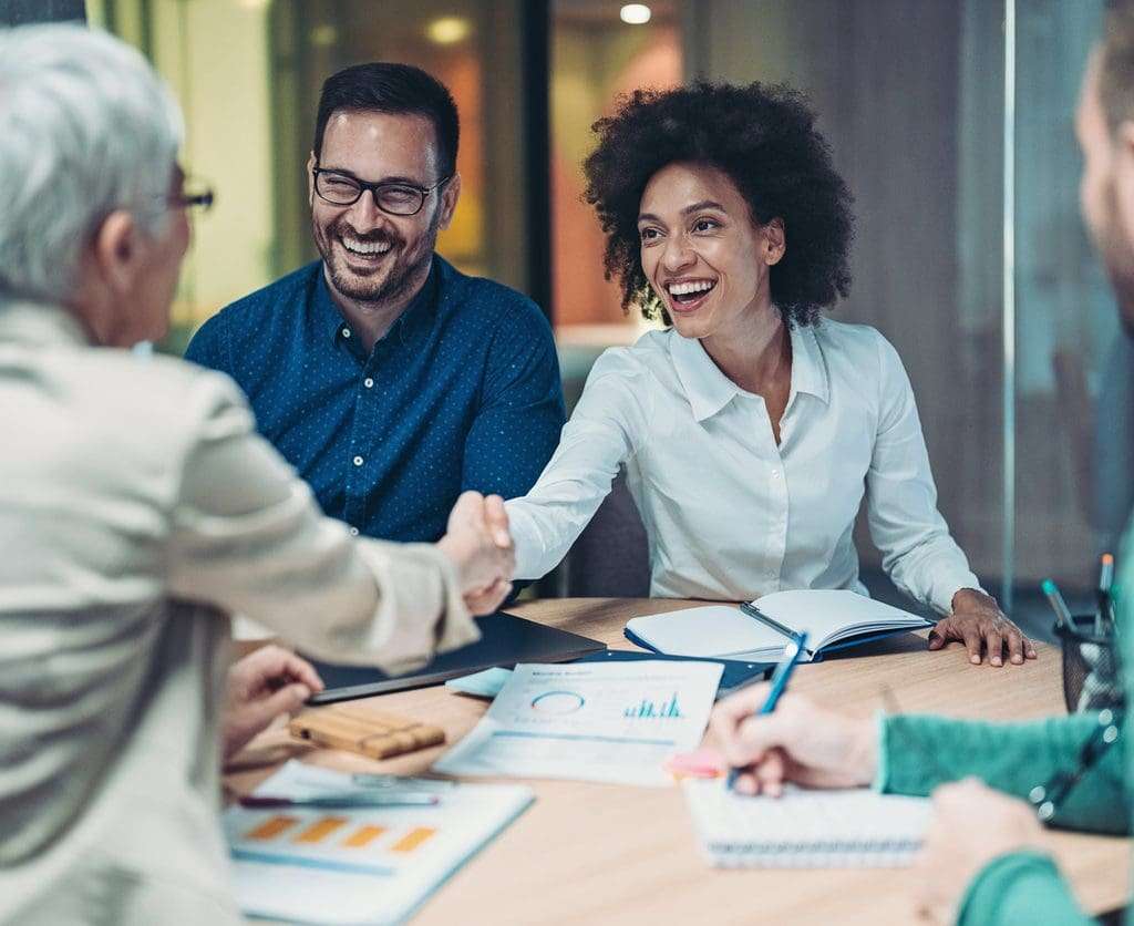 Smiling businesswomen handshake over the table