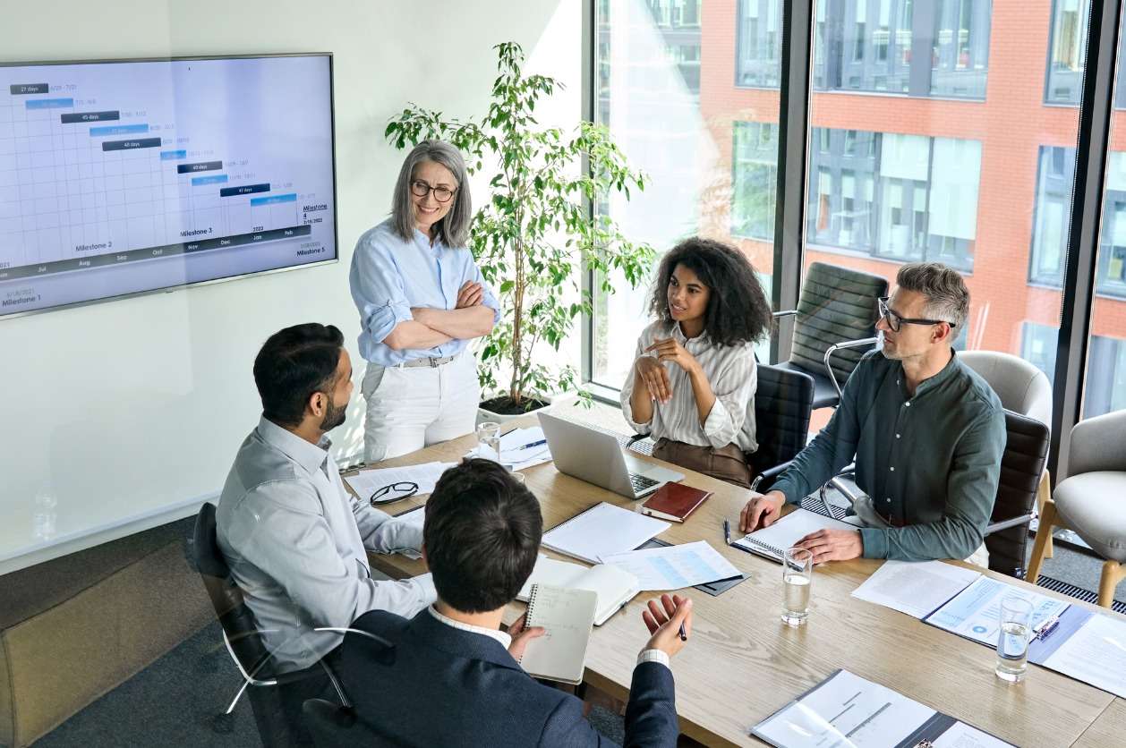 Global workforce management strategies - A businesswoman having a meeting with her employees in a conference room.
