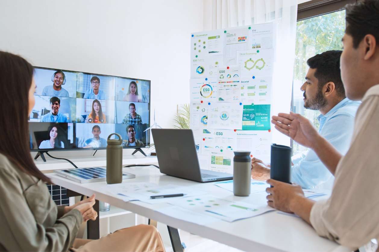 Setting performance objectives and KPIs - A group of business owners in an office having a virtual meeting with their remote employees.