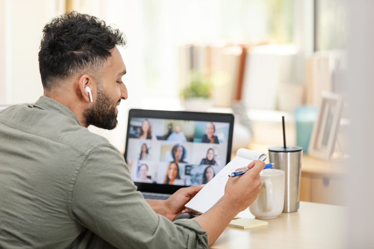 Time zone communication strategies - A man at home having a virtual meeting with his colleagues.