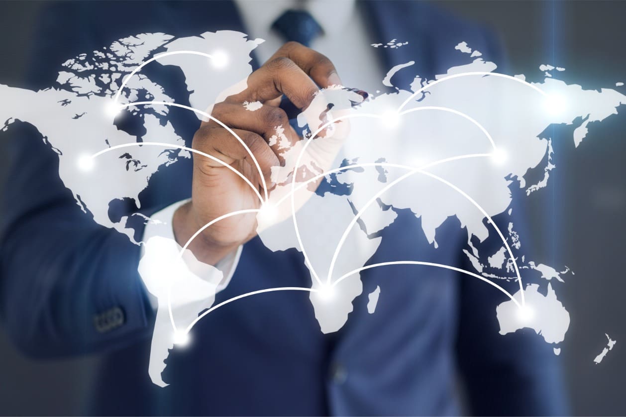 Scaling operations across borders - A businessman using a pen to point different countries on a digital map.