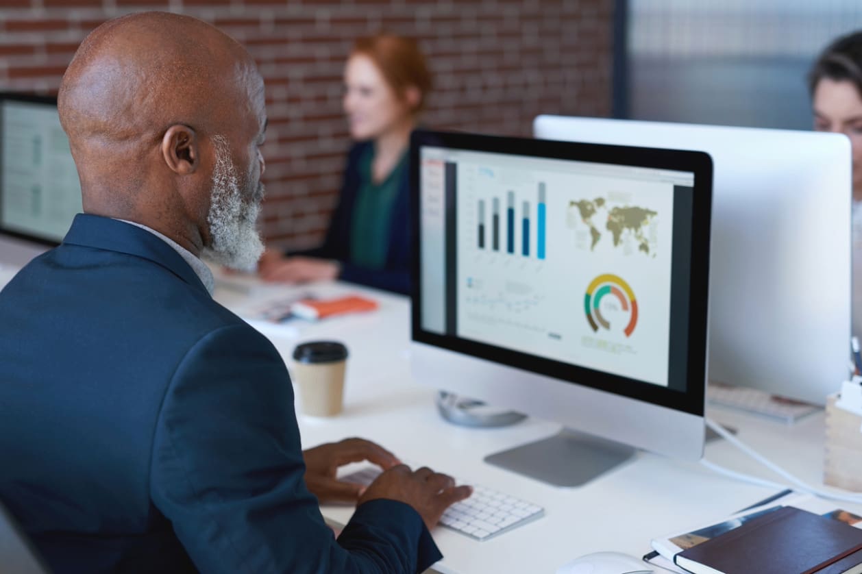 International business expansion - A businessman using a computer to track his teams' productivity.